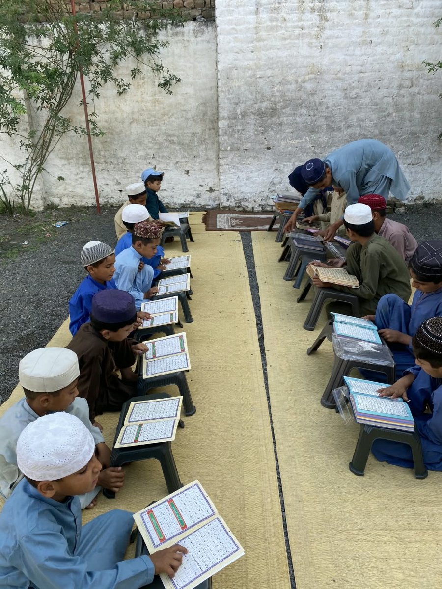 Madrasah students reading Noorani Qaida on Quran desks provided by IRT Foundation