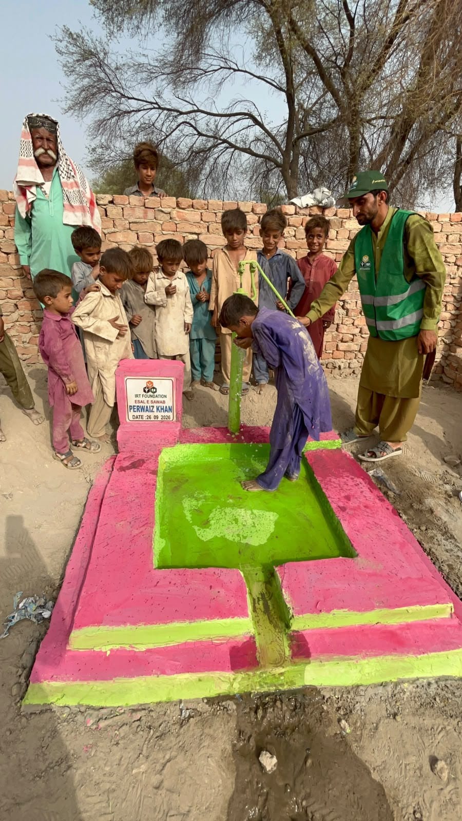 Children drinking clean water from a sadaqah jariyah water well hand pump